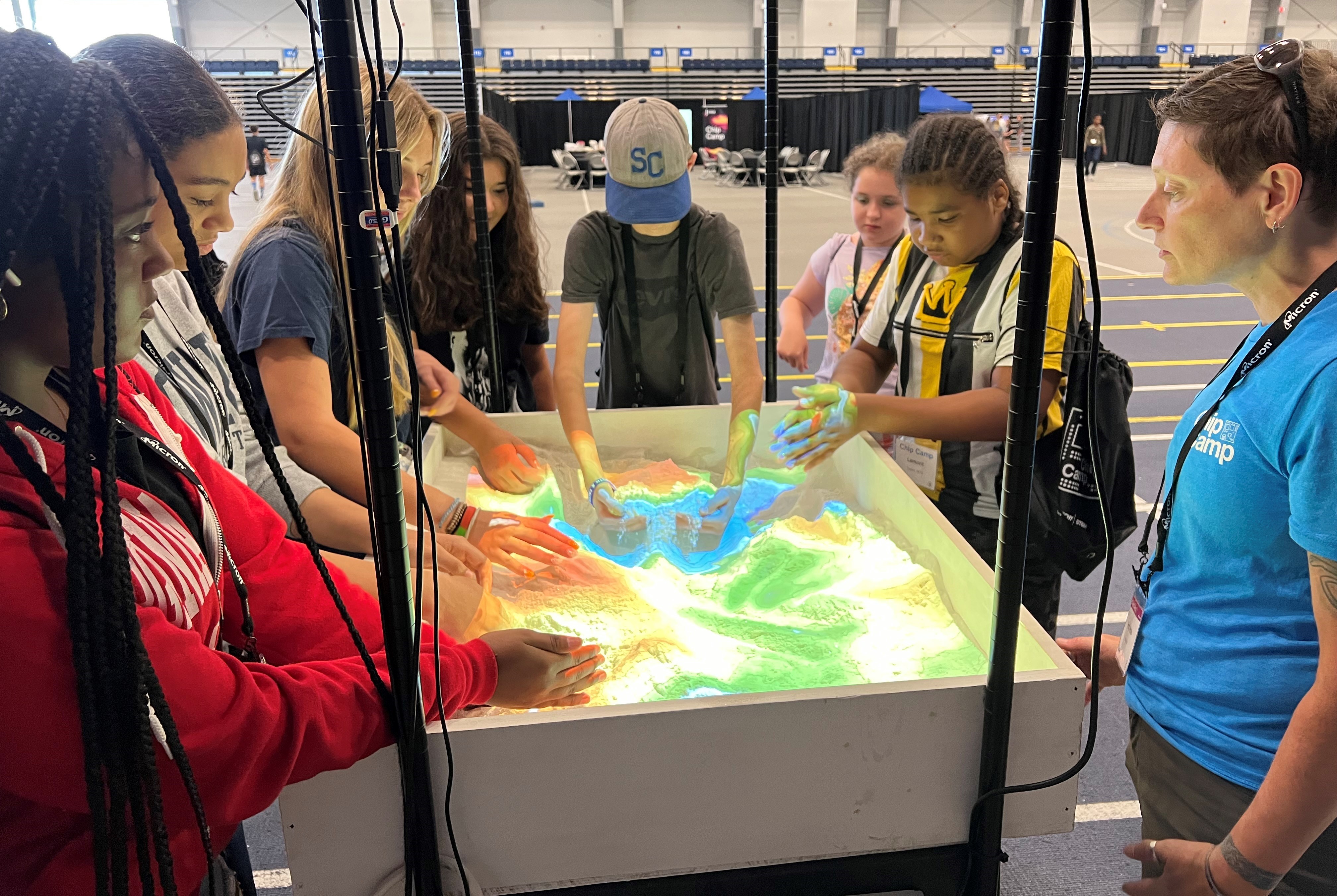 Professor Melissa Hicks (right) works with students exploring the virtual sandbox at the Micron-sponsored Chip Camp.